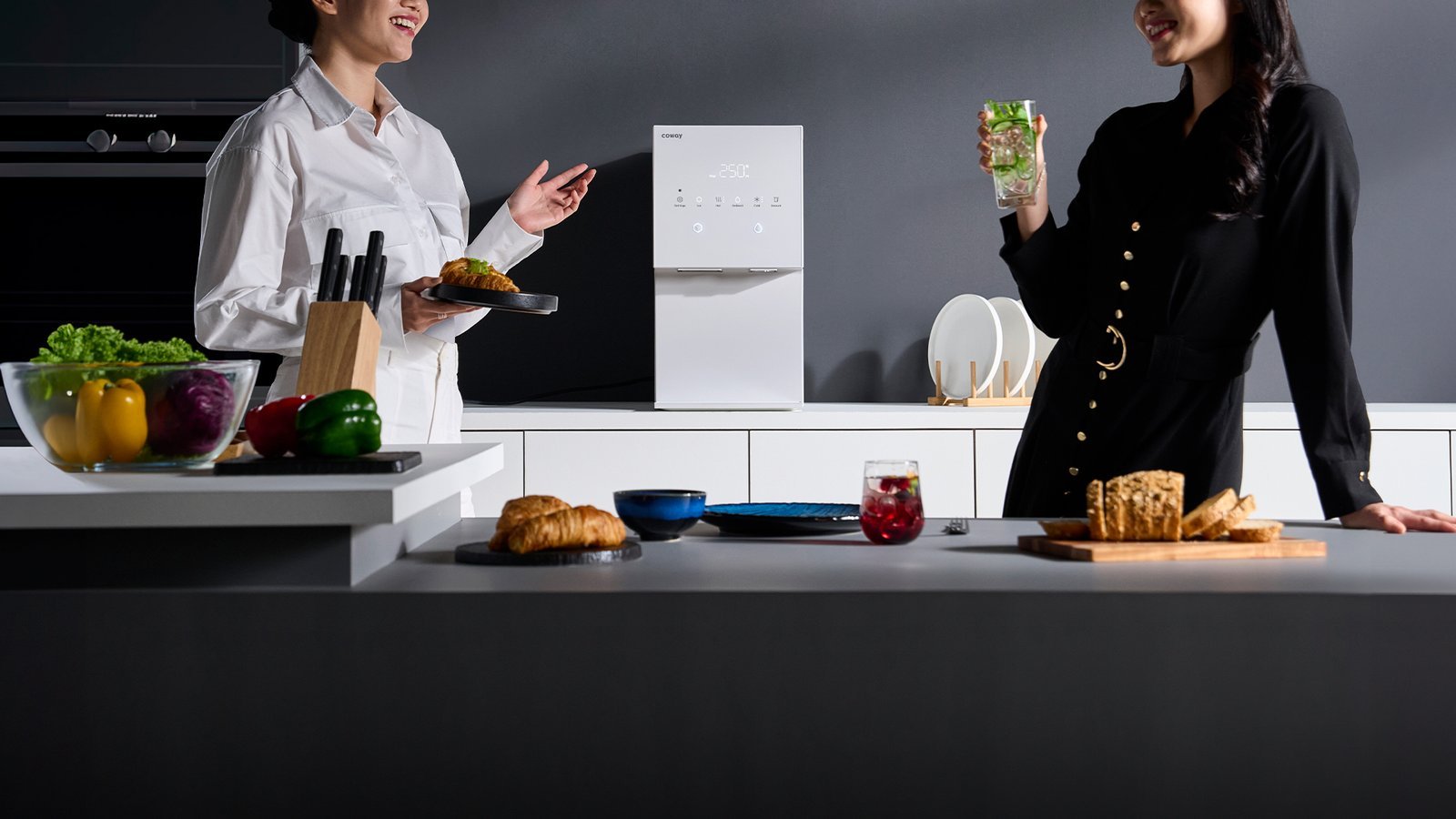 Two people sharing iced drinks and food beside the Coway Ais on a kitchen island